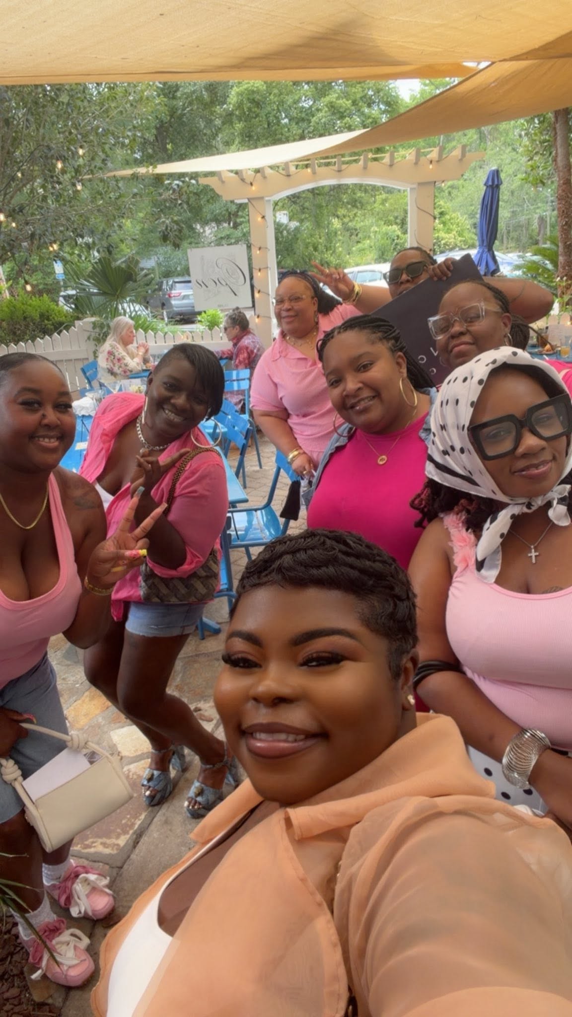 Between Covers members taking a group selfie on a cafe patio